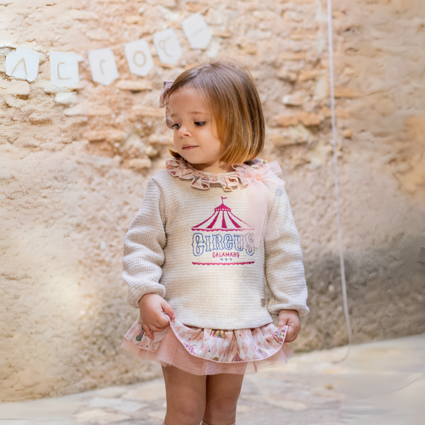 Completo circus.
Blusa in maglia felpata con ricamo, collo volant fantasia con fiocco in tulle.
Culotte fantasia in coordinato con volant e tulle.